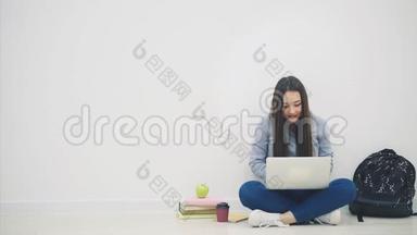 一位亚洲女士<strong>坐</strong>在地板上，<strong>坐</strong>在洛托斯的位置上，拿着笔记本电脑，举起<strong>双手</strong>，指着一件非常重要的东西